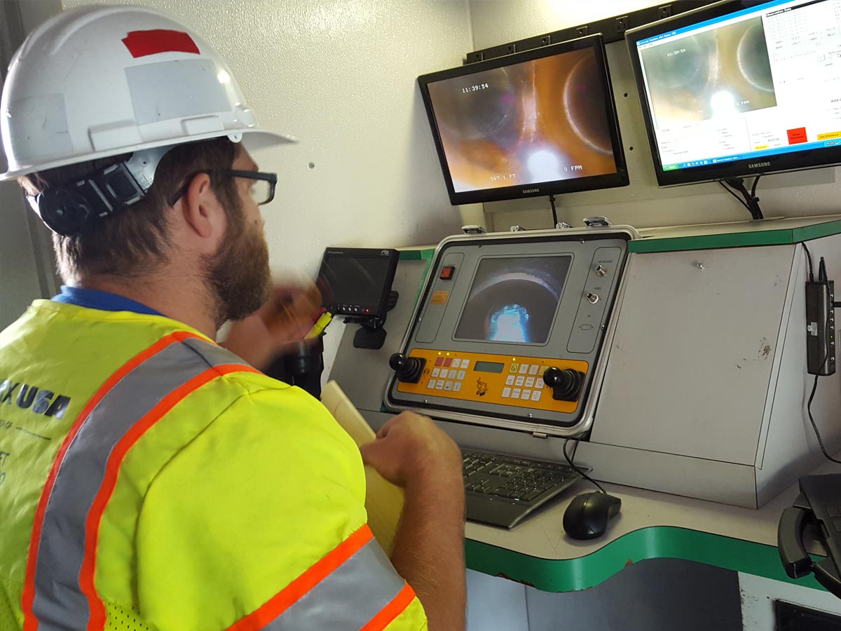 A Hydromax worker using a specialized computer console to monitor the inside of a pipeline.