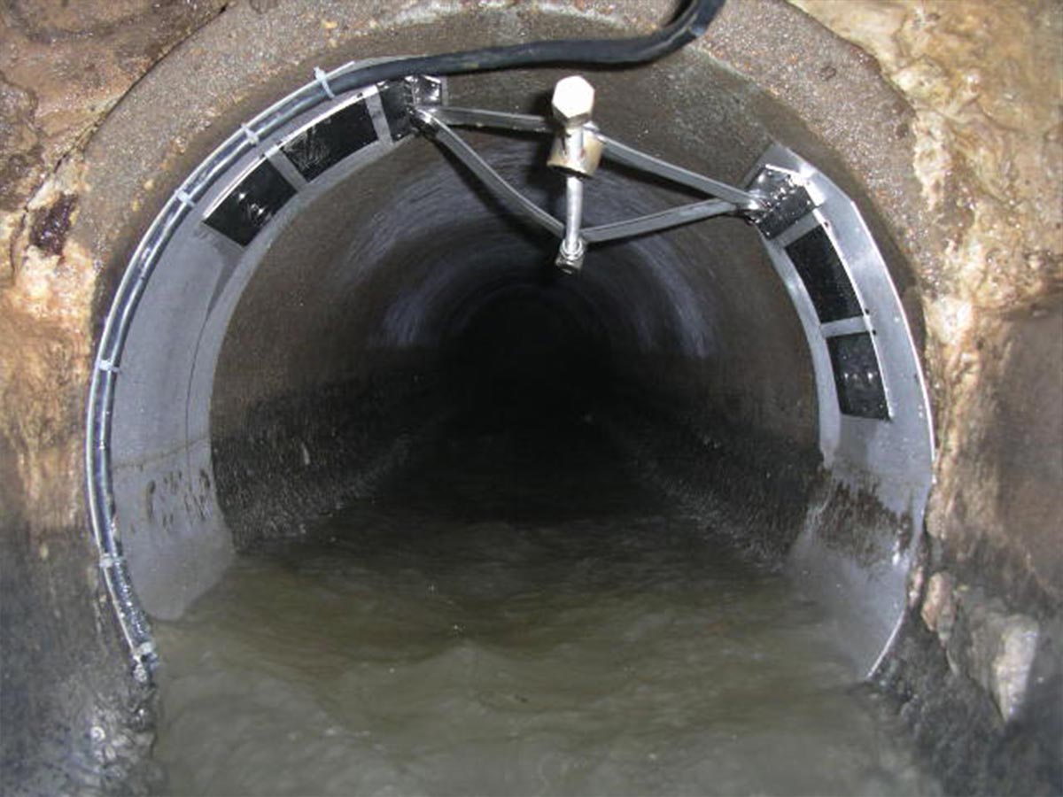 The interior of a sewer pipe with a Flow Monitor sensor installed.