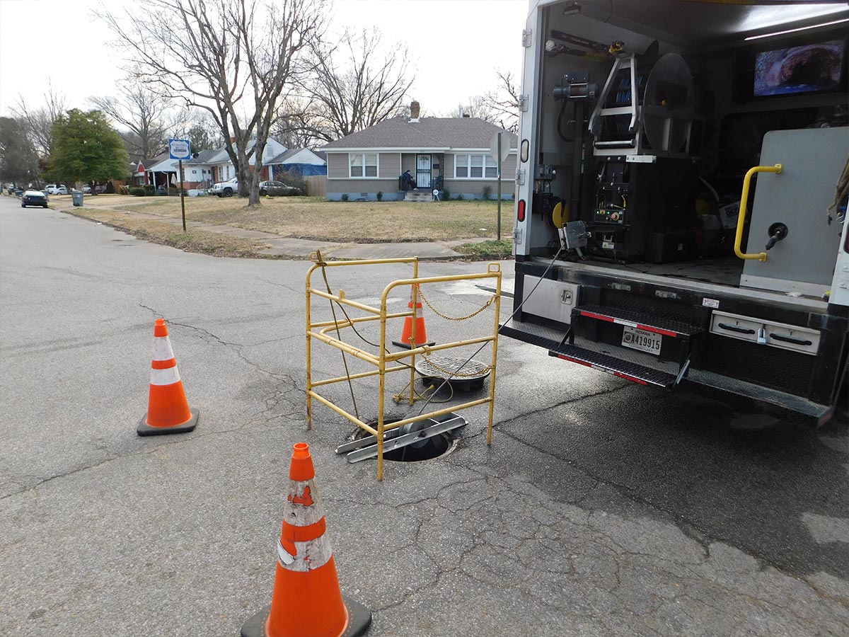 A manhole that has been cordoned off behind a HydroMax USA truck in preparation for an inspection.